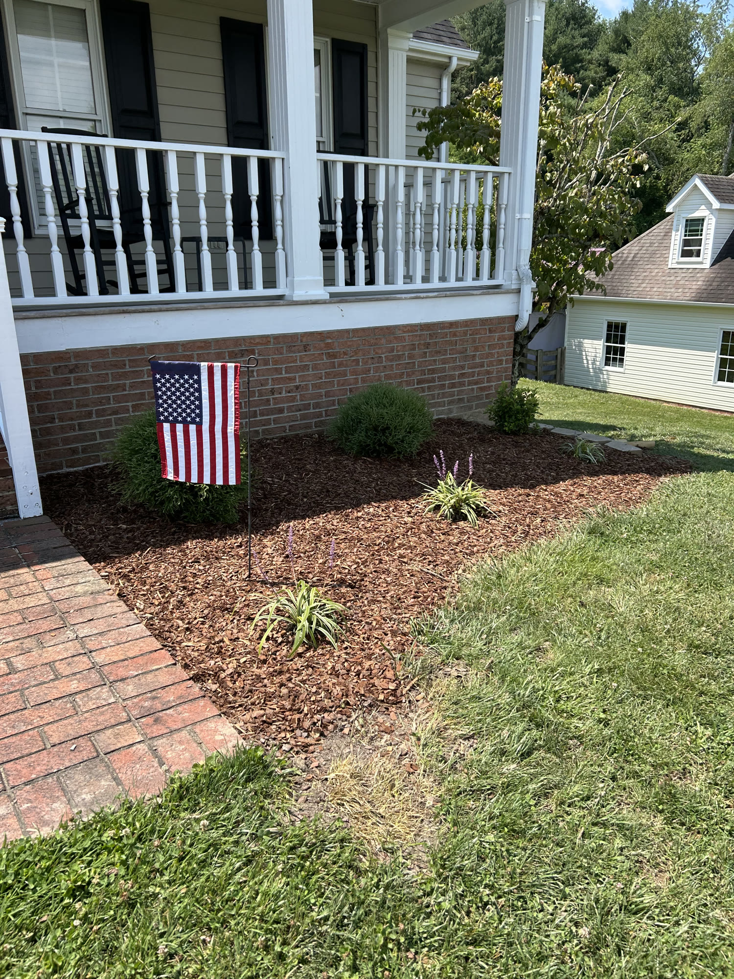 Fresh mulch bed and plantings along a front porch